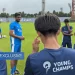 Chembakath holding a football, RFYC training pitch behind